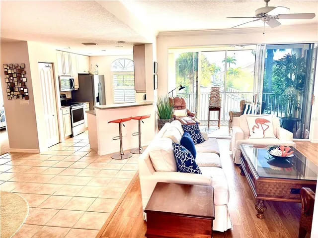 a living room with furniture kitchen view and a large mirror