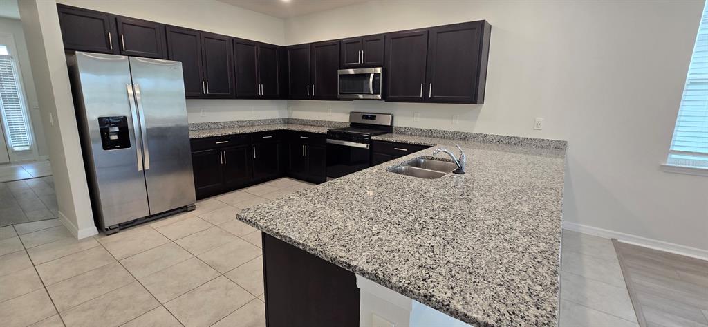 7193 Southwest 64th St Road Ocala, FL 34474 - Photo 2 of 17 a kitchen with stainless steel appliances granite countertop a sink stove and refrigerator