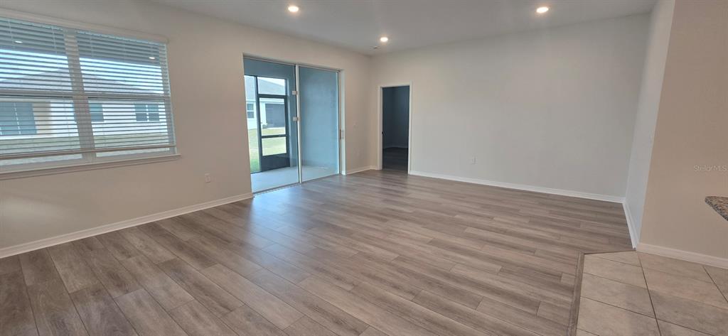 7193 Southwest 64th St Road Ocala, FL 34474 - Photo 6 of 17 a view of an empty room with wooden floor and windows