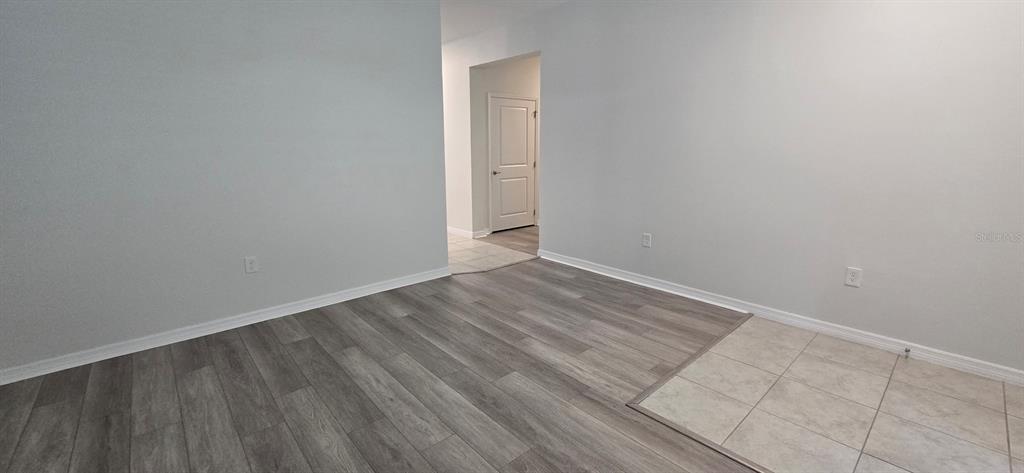 7193 Southwest 64th St Road Ocala, FL 34474 - Photo 9 of 17 a view of an empty room with wooden floor and a window