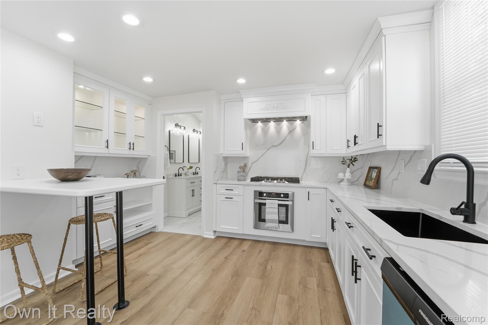 168 Kerby Road Grosse Pointe, MI 48236 - Photo 9 of 36 Recessed lighting illuminates the white cabinetry and wood-finish flooring