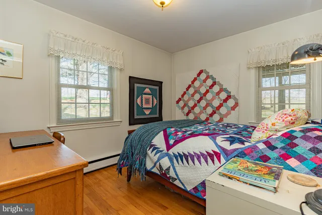 a bedroom with three beds and a window