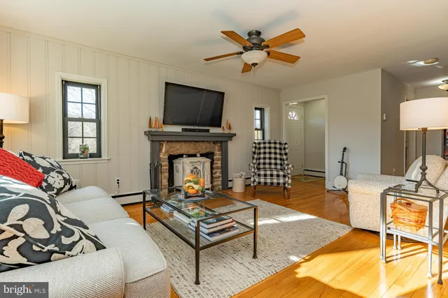 a living room with furniture a flat screen tv and a window