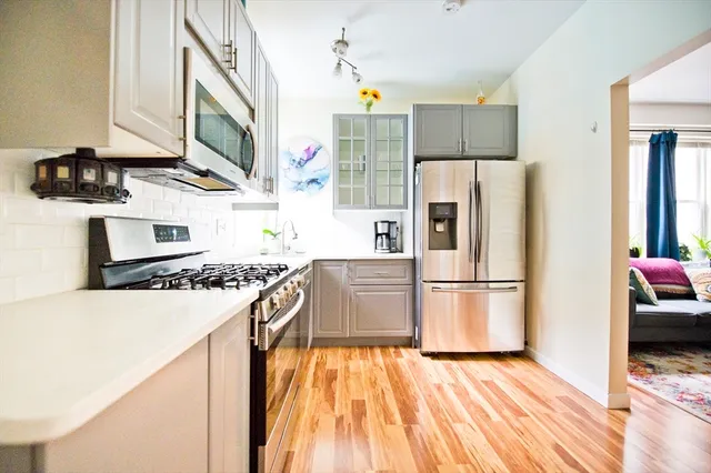 a kitchen with a refrigerator a stove top oven a sink and cabinets