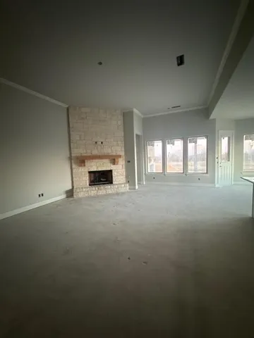an empty room with fireplace and windows
