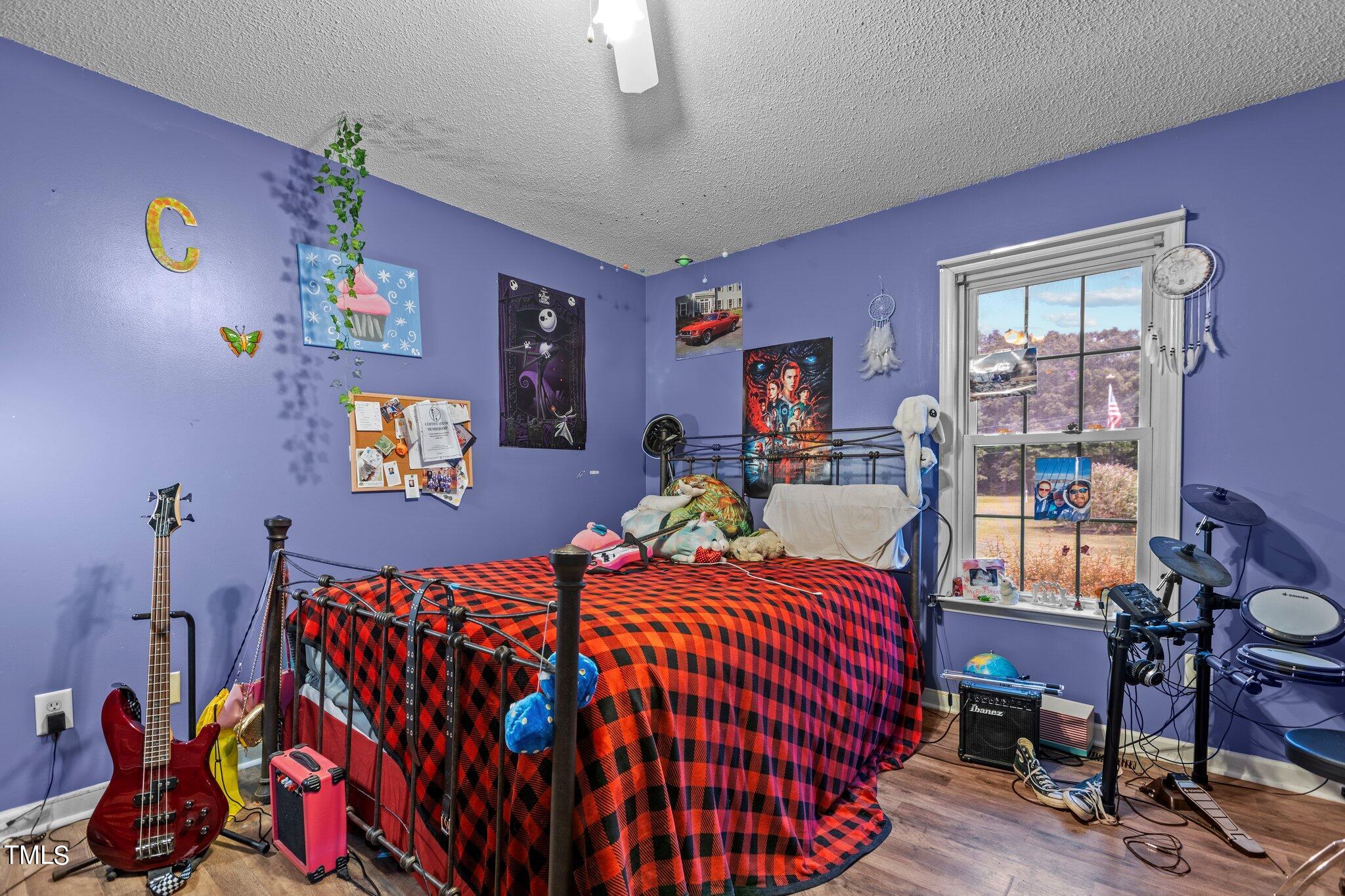 810 Willie Gray Road Timberlake, NC 27583 - Photo 17 of 28 a bedroom with a bed and wooden floor