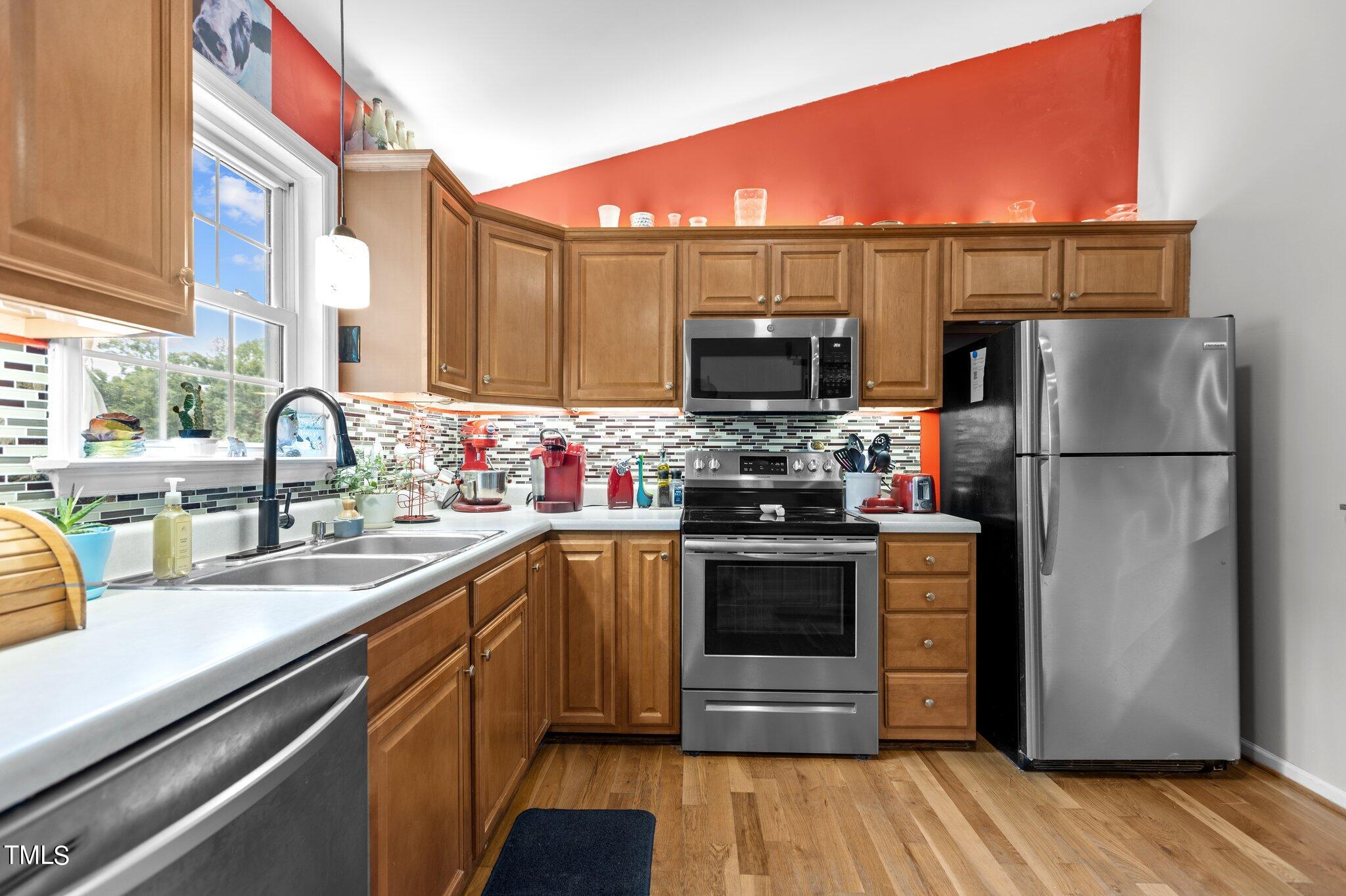 810 Willie Gray Road Timberlake, NC 27583 - Photo 8 of 28 a kitchen with stainless steel appliances a stove a sink and a refrigerator
