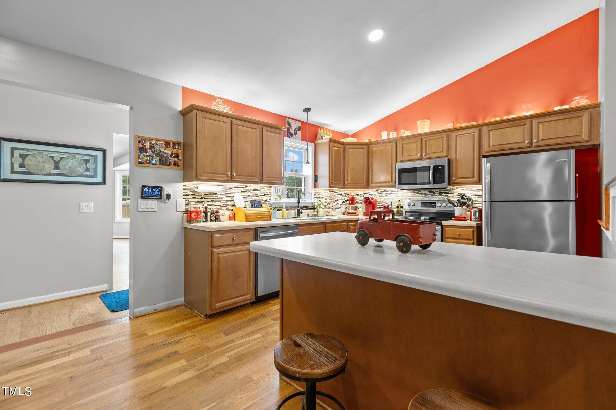 810 Willie Gray Road Timberlake, NC 27583 - Photo 9 of 28 a kitchen with refrigerator and chairs