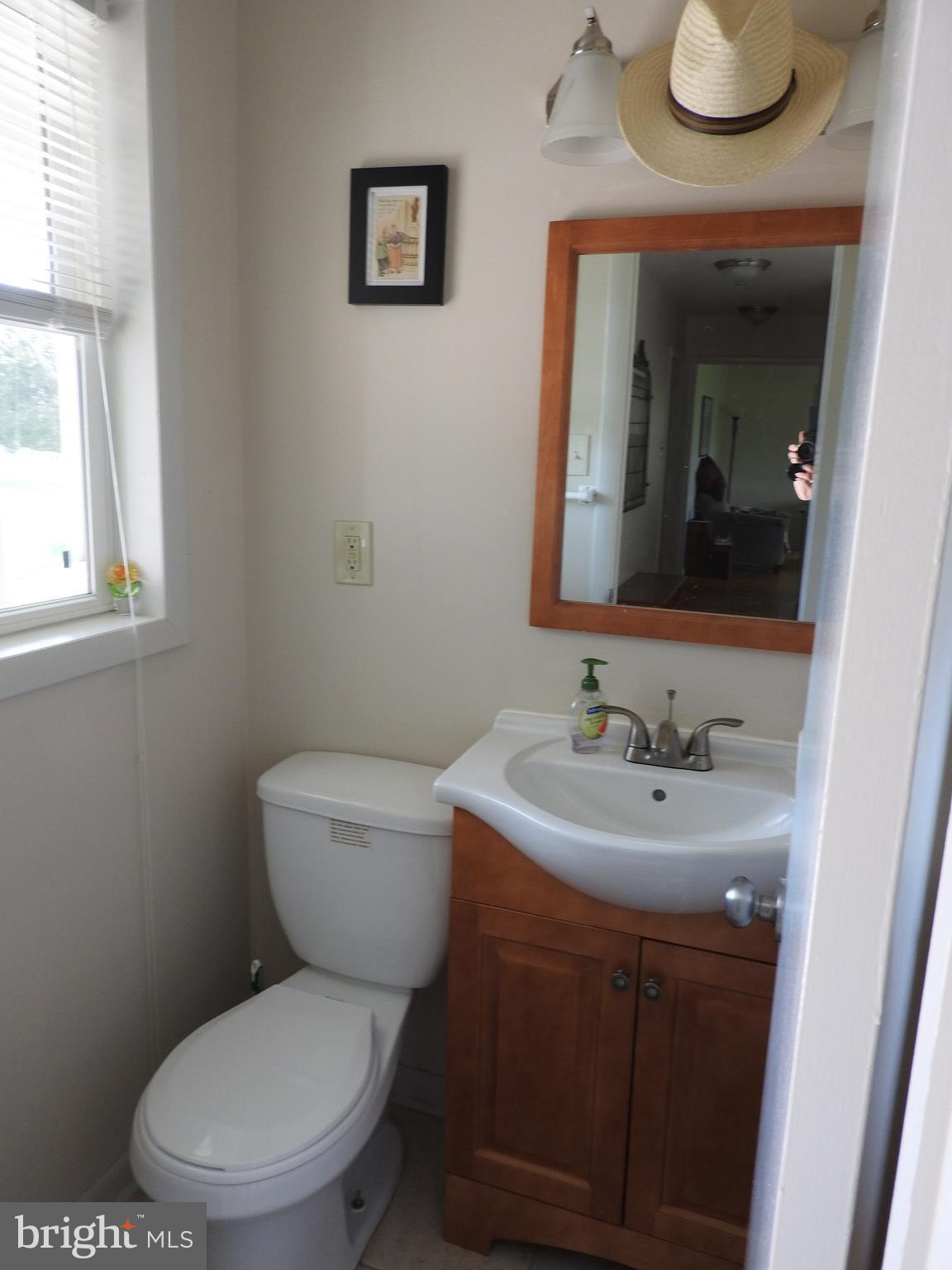 2711 Bel Pre Road Silver Spring, MD 20906 - Photo 18 of 19 a bathroom with a toilet a sink and mirror