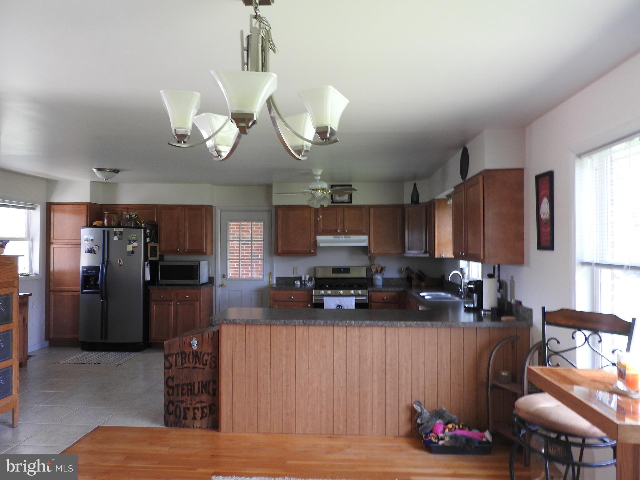 2711 Bel Pre Road Silver Spring, MD 20906 - Photo 5 of 19 a kitchen with stainless steel appliances granite countertop a sink dishwasher a refrigerator a microwave oven with cabinets and wooden floor