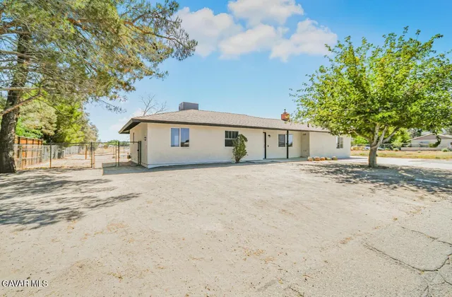 a front view of a house with a tree