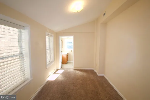 a view of a bedroom with a window and a bathroom