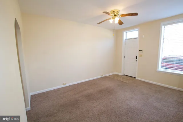 an empty room with closet and a chandelier fan