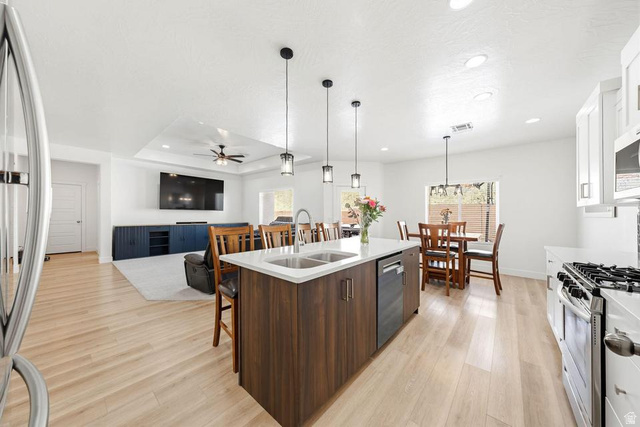 5963 Flattop Drive St. George, UT 84790 - Photo 12 of 45 Open-concept kitchen featuring a central island with dual sinks, light wood-finish flooring, white cabinetry, stainless steel appliances, and recessed lighting