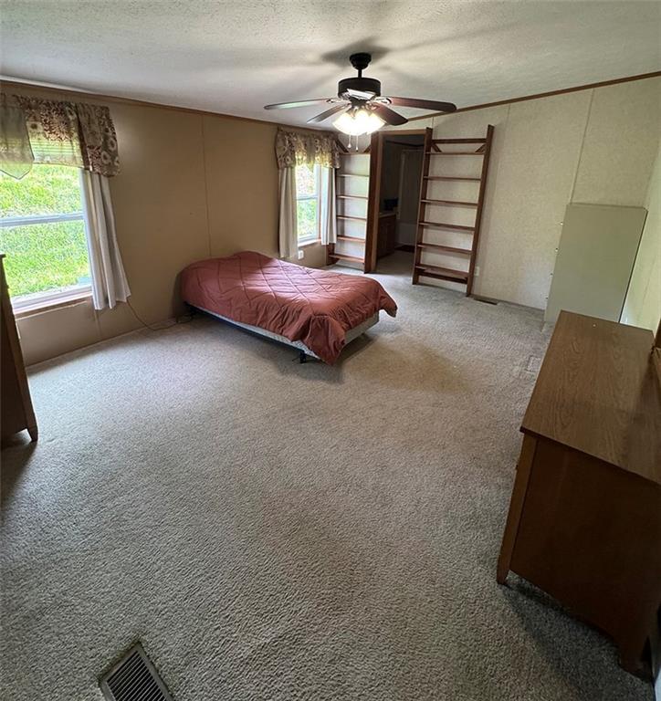 700 Kimmel Road Home, PA 15747 - Photo 8 of 14 a spacious bedroom with a bed and a chandelier