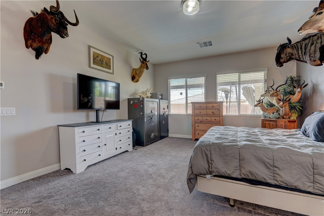 5967 Yellow Ridge Avenue Las Vegas, NV 89131 - Photo 13 of 33 This spacious bedroom offers ample natural light and plush carpeted flooring, creating a comfortable living space.