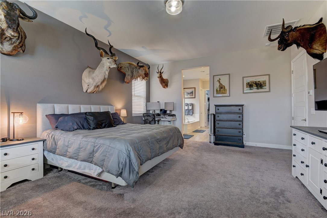 5967 Yellow Ridge Avenue Las Vegas, NV 89131 - Photo 14 of 33 Relax and unwind in this spacious bedroom featuring plush carpeting and an adjoining bathroom.