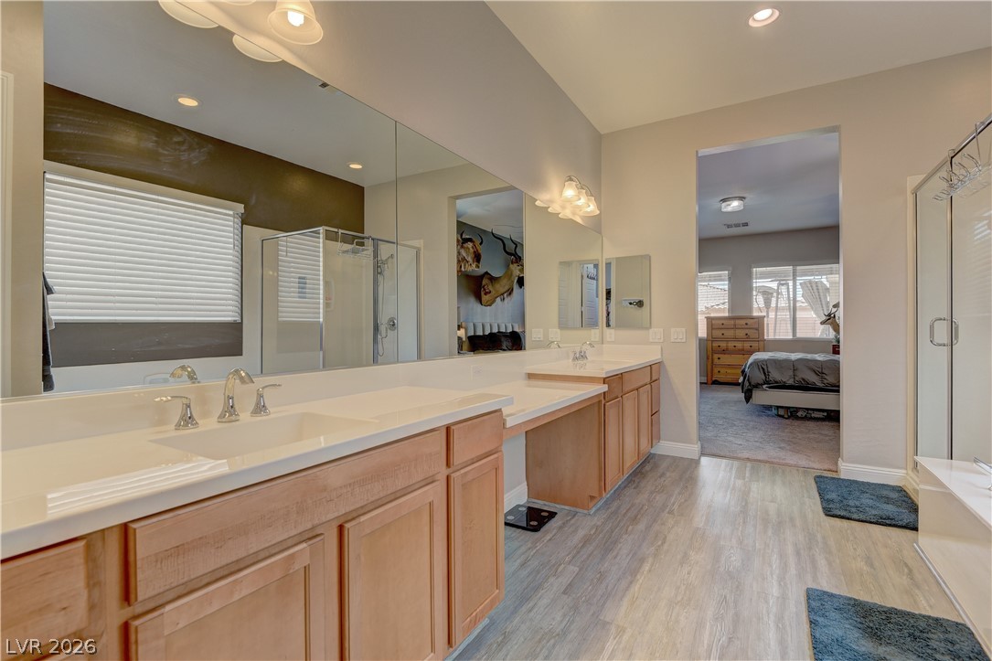 5967 Yellow Ridge Avenue Las Vegas, NV 89131 - Photo 15 of 33 This spacious primary bathroom features dual vanities and a large glass-enclosed shower, offering comfort and style.