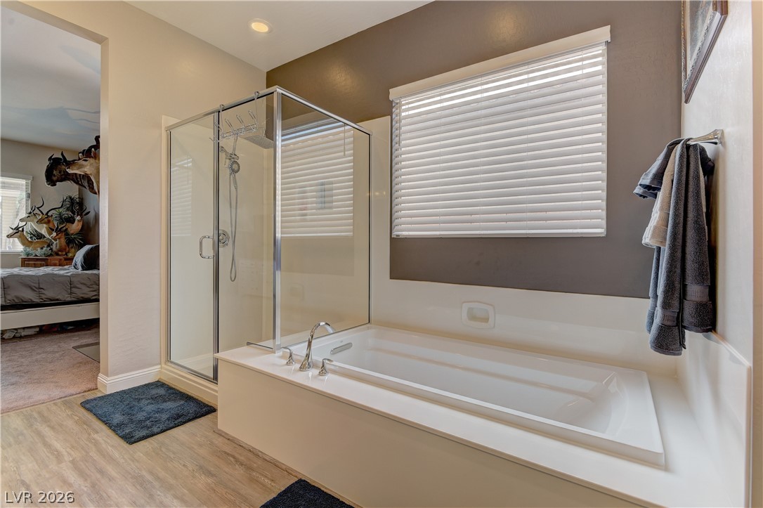 5967 Yellow Ridge Avenue Las Vegas, NV 89131 - Photo 16 of 33 This primary bathroom features a spacious soaking tub and a sleek glass-enclosed shower.