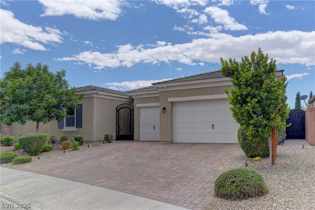 5967 Yellow Ridge Avenue Las Vegas, NV 89131 - Photo 2 of 33 This charming residence presents a two-car garage, mature landscaping, and a welcoming paver driveway.