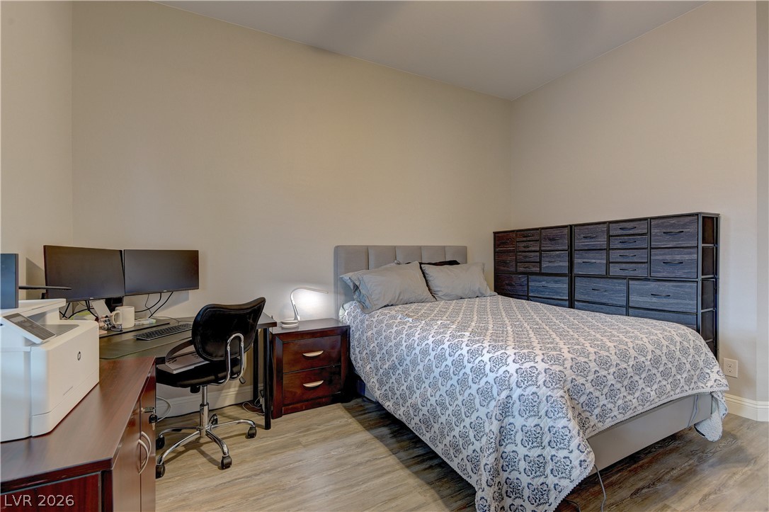 5967 Yellow Ridge Avenue Las Vegas, NV 89131 - Photo 21 of 33 This spacious bedroom offers a versatile layout, ideal for both restful nights and productive workdays.