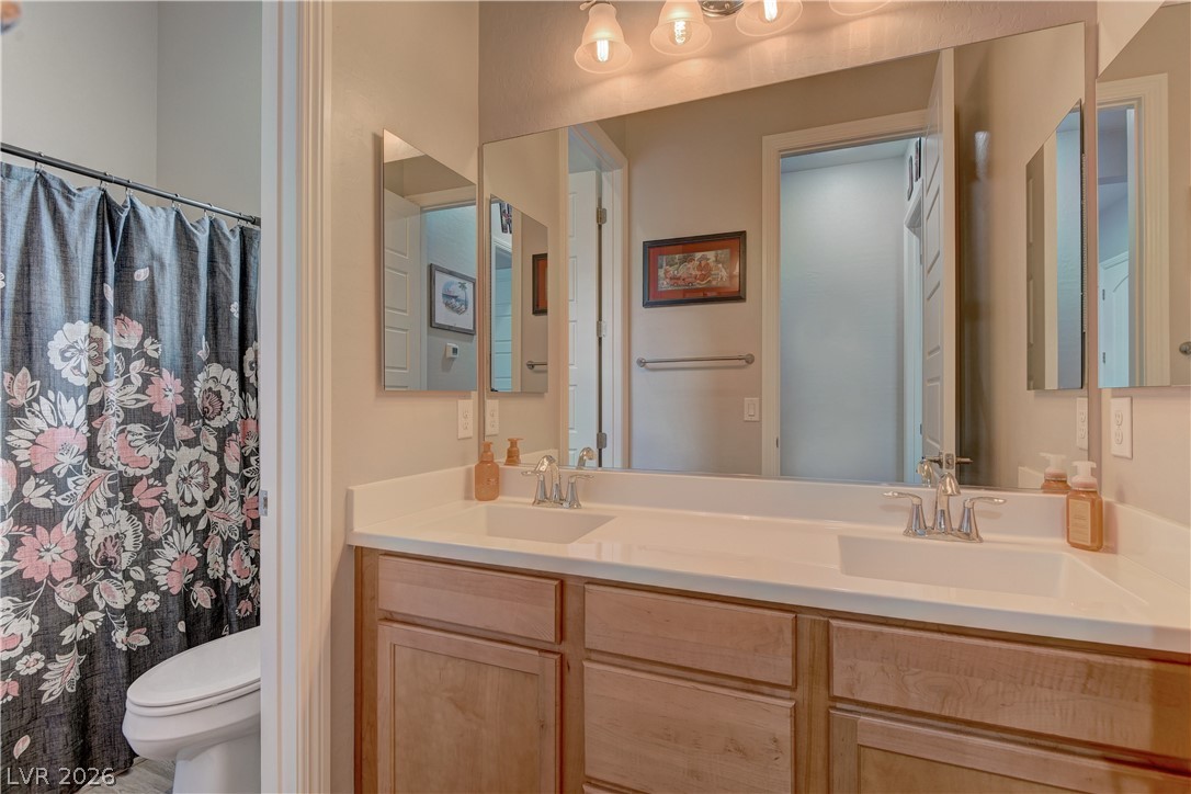 5967 Yellow Ridge Avenue Las Vegas, NV 89131 - Photo 24 of 33 This bathroom features a double vanity and sleek countertops, providing ample space and modern convenience.