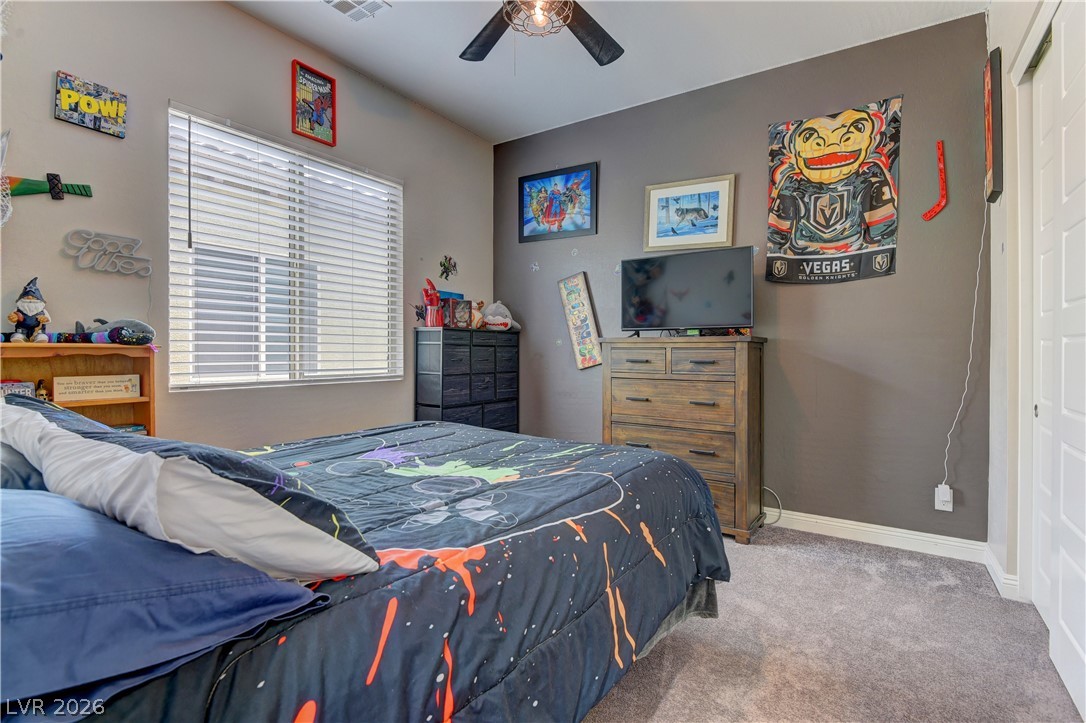 5967 Yellow Ridge Avenue Las Vegas, NV 89131 - Photo 25 of 33 This cozy bedroom features a window with blinds and soft carpeting, creating a comfortable retreat.