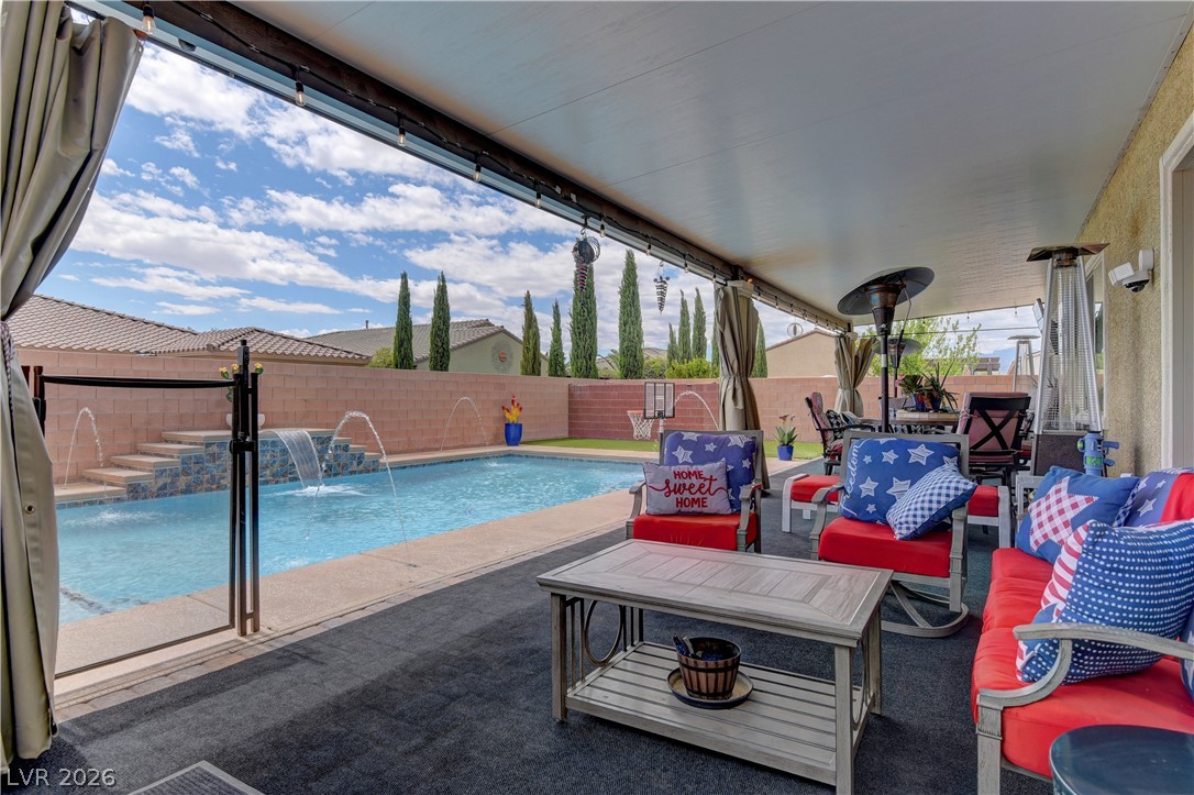 5967 Yellow Ridge Avenue Las Vegas, NV 89131 - Photo 27 of 33 Enjoy outdoor living with a covered patio overlooking a refreshing pool with water features.