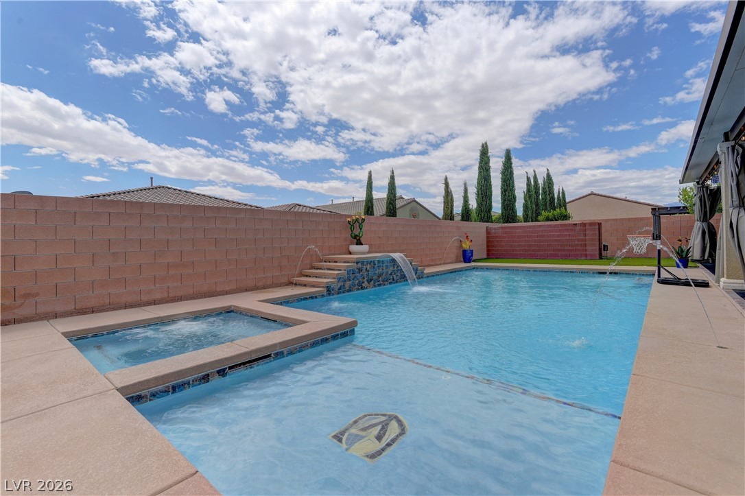 5967 Yellow Ridge Avenue Las Vegas, NV 89131 - Photo 29 of 33 This spacious backyard features a sparkling pool and spa, perfect for relaxation and recreation.