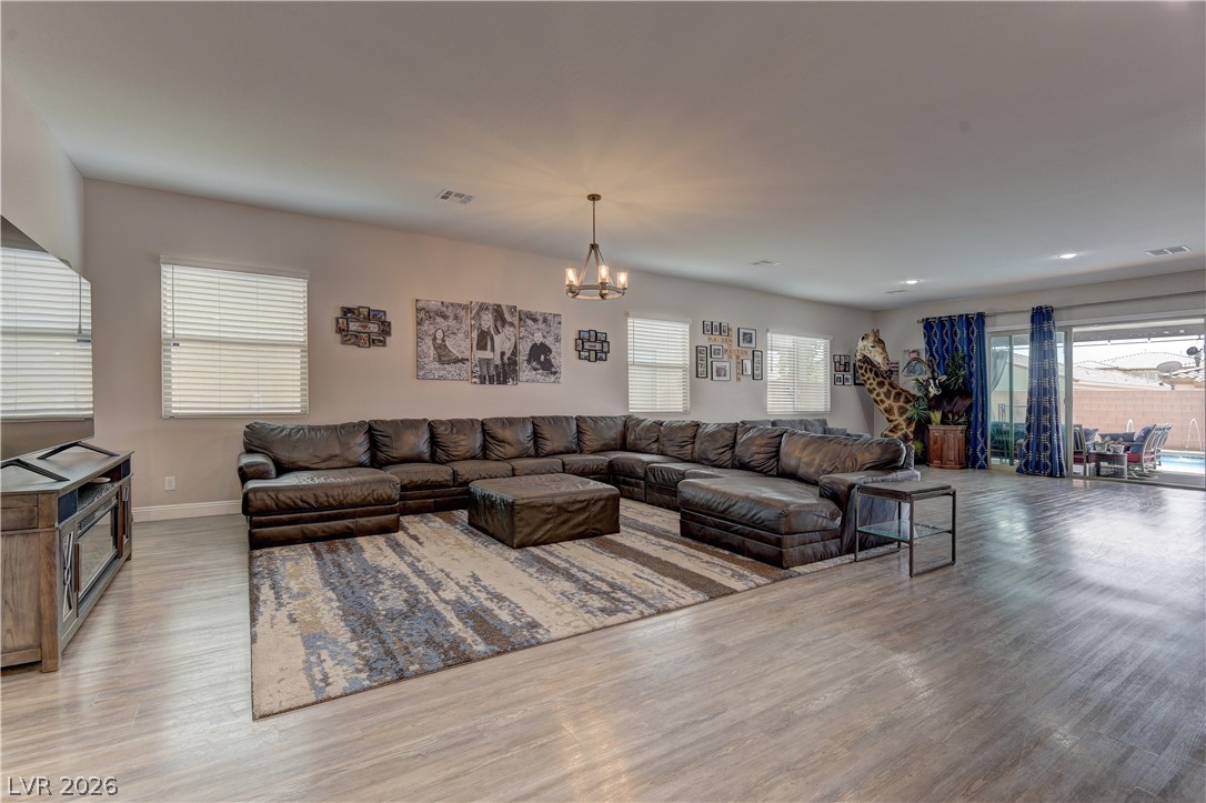 5967 Yellow Ridge Avenue Las Vegas, NV 89131 - Photo 33 of 33 This inviting living area boasts an open floorplan with durable flooring and large windows, connecting seamlessly to outdoor living.