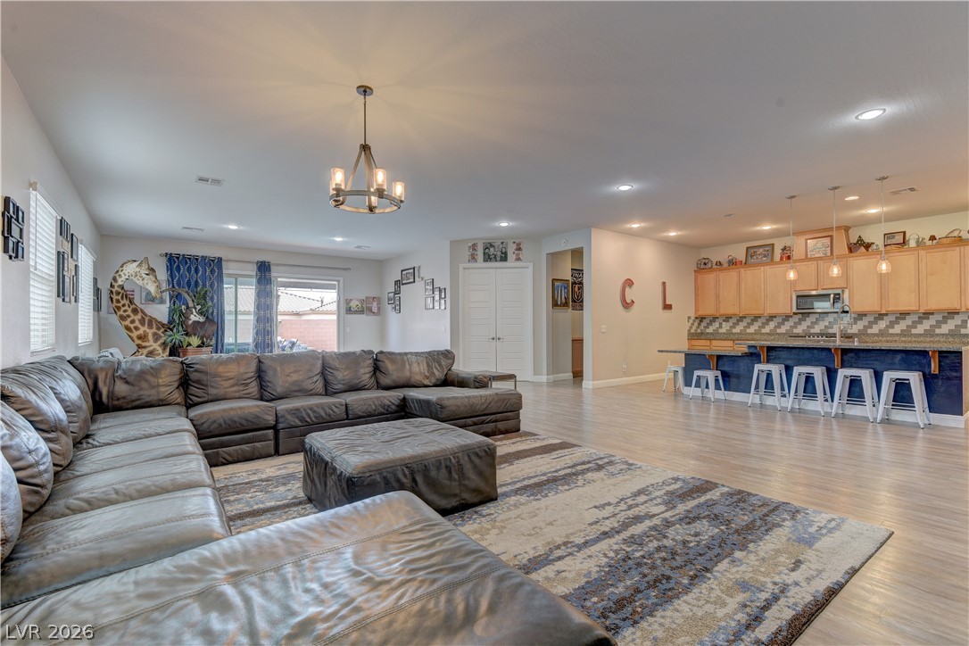 5967 Yellow Ridge Avenue Las Vegas, NV 89131 - Photo 5 of 33 This expansive great room seamlessly blends living and kitchen areas with light flooring and recessed lighting.