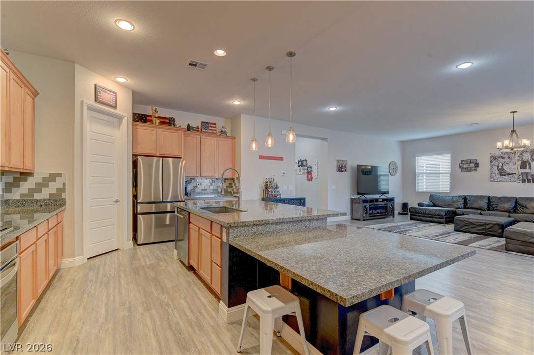 5967 Yellow Ridge Avenue Las Vegas, NV 89131 - Photo 7 of 33 This open concept living space features a spacious kitchen island and a well-appointed kitchen flowing into the living area.