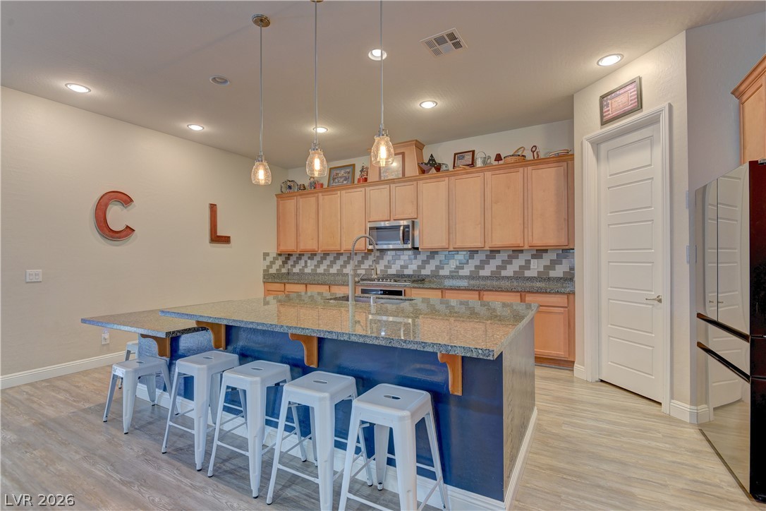 5967 Yellow Ridge Avenue Las Vegas, NV 89131 - Photo 8 of 33 This modern kitchen features a spacious island with seating, ample cabinetry, and sleek appliances.