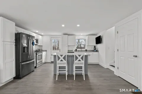 a kitchen with stainless steel appliances a refrigerator and wooden floor