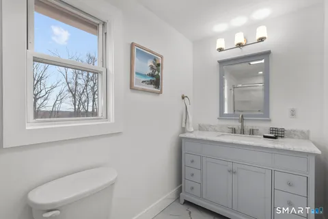 a bathroom with a toilet a sink and mirror