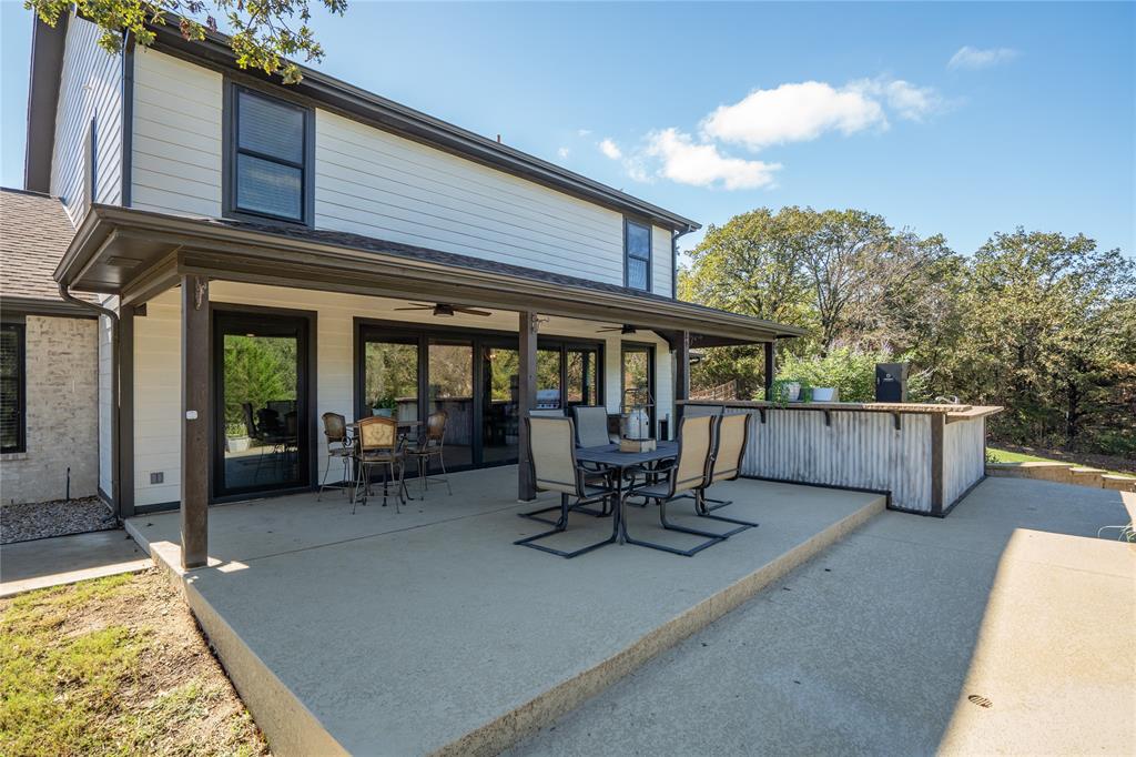 950 Naylor Road Cross Roads, TX 76227 - Photo 28 of 40 a view of a patio with table and chairs and wooden fence