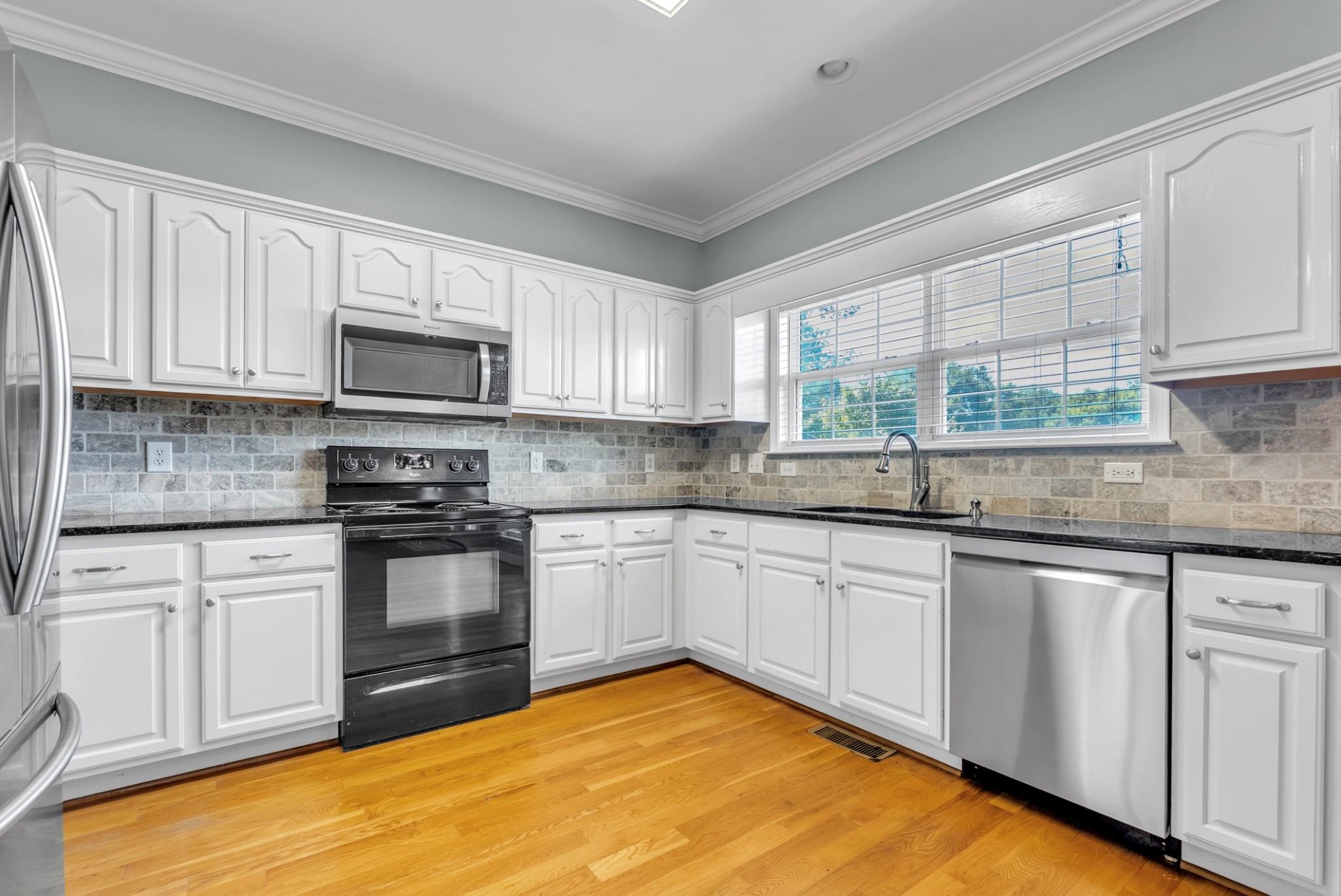 3848 Kedron Road Spring Hill, TN 37174 - Photo 7 of 33 a kitchen with granite countertop a sink cabinets and stainless steel appliances