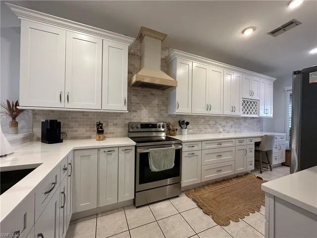 a kitchen with a stove sink and cabinets