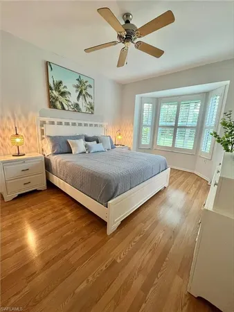 a bedroom with a large bed and a chandelier fan
