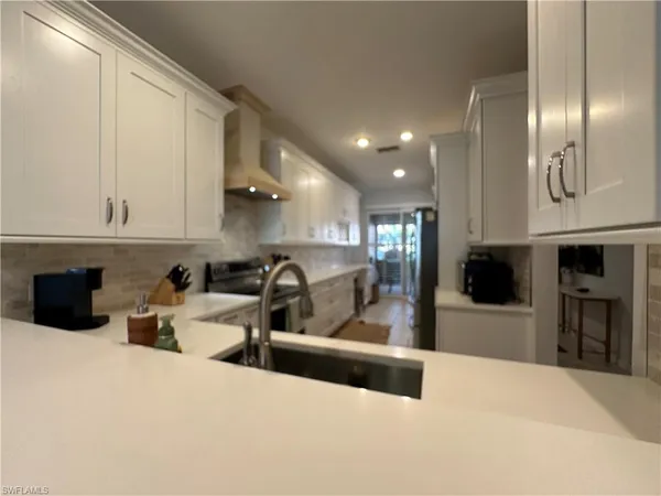 a kitchen with stainless steel appliances kitchen island granite countertop a refrigerator and microwave