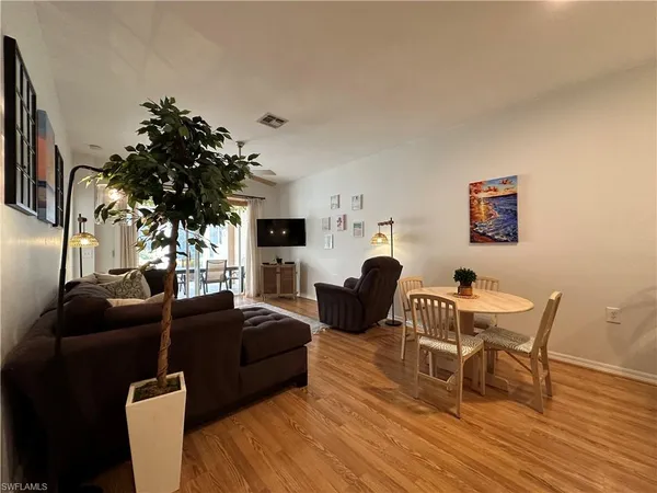 a living room with furniture a dining table and a potted plant