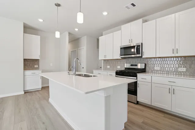 a kitchen with a sink a stove and cabinets