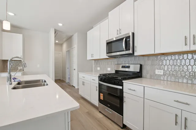 a kitchen with stainless steel appliances granite countertop a sink stove and microwave