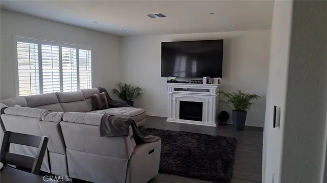 a living room with furniture a flat screen tv and a fireplace