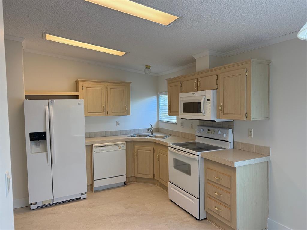 8648 Southwest 16th Place Davie, FL 33324 - Photo 2 of 10 a kitchen with white cabinets and white appliances