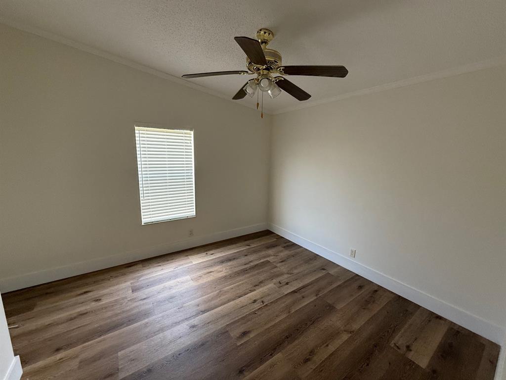 8648 Southwest 16th Place Davie, FL 33324 - Photo 9 of 10 an empty room with wooden floor fan and windows