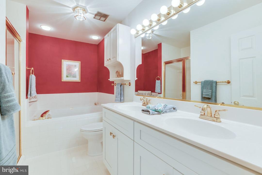 11446 Hollow Timber Court Reston, VA 20194 - Photo 22 of 29 a bathroom with a bath tub sink mirror vanity and toilet