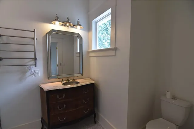 an empty room with wooden floor fireplace and windows