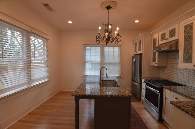 a kitchen with granite countertop a sink stove and refrigerator