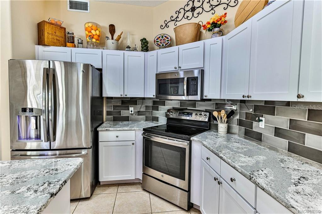5420 North Rosedale Circle Beverly Hills, FL 34465 - Photo 12 of 49 a kitchen with stainless steel appliances granite countertop a refrigerator sink and stove